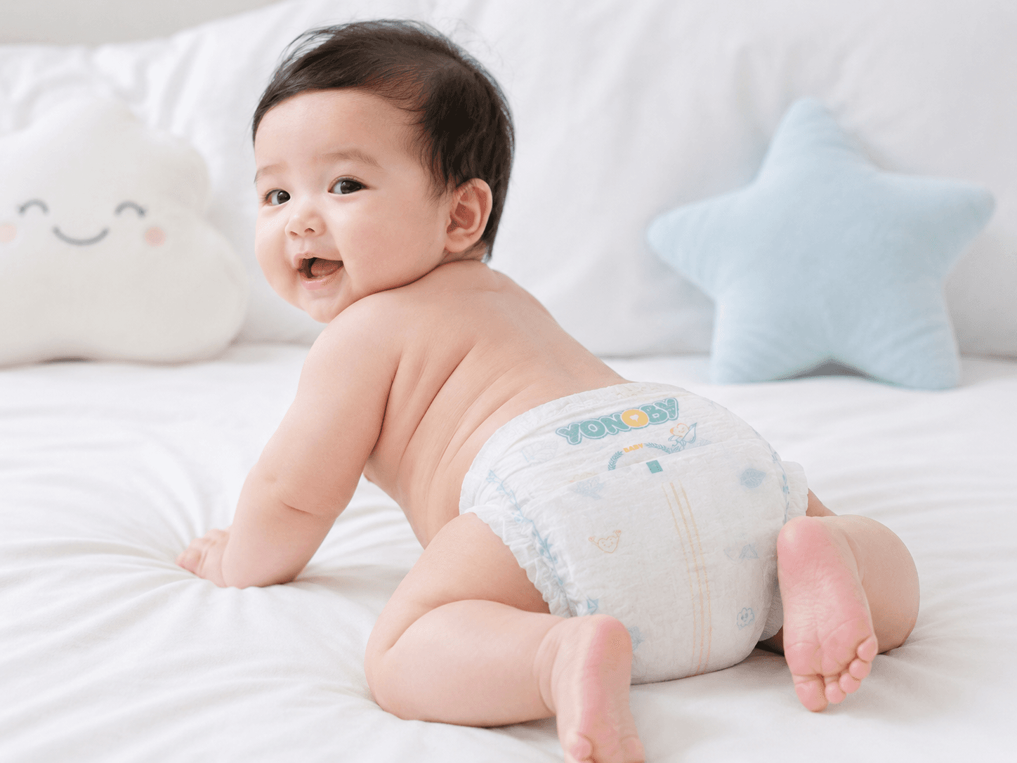 Em bé mặc tã Yonoby, cười tươi trên giường